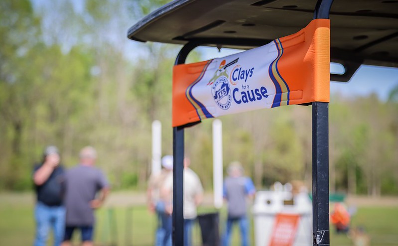 An orange and white banner that says "Clays Cause".