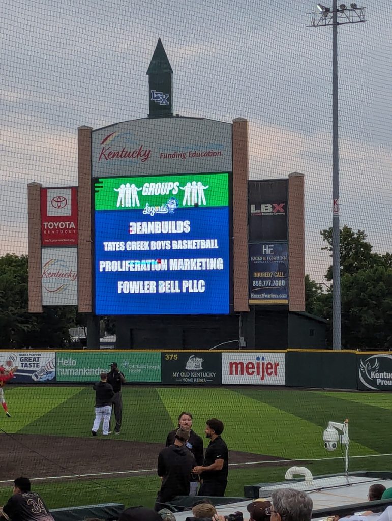 A baseball field with a big screen.